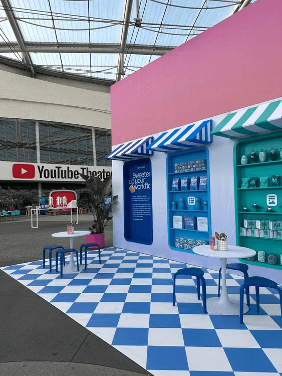 Colourful exhibition booth with branded displays and seating at an event venue