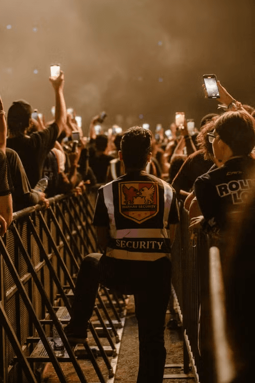 Security staff managing crowd barriers at a large live event