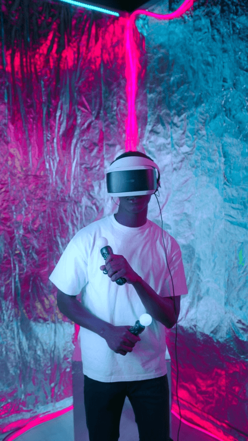 Person using VR headset in a neon-lit technology space